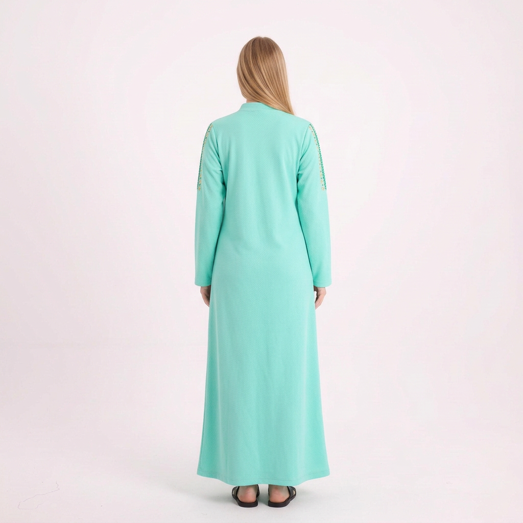 Back view of our blonde model in the bright mint abaya on a white background