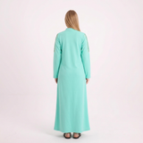 Back view of our blonde model in the bright mint abaya on a white background